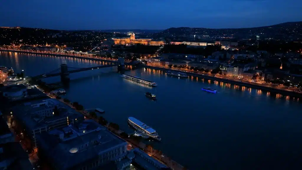Aerial drone night dolly shot of river cruise ships, Budapest, Hungary