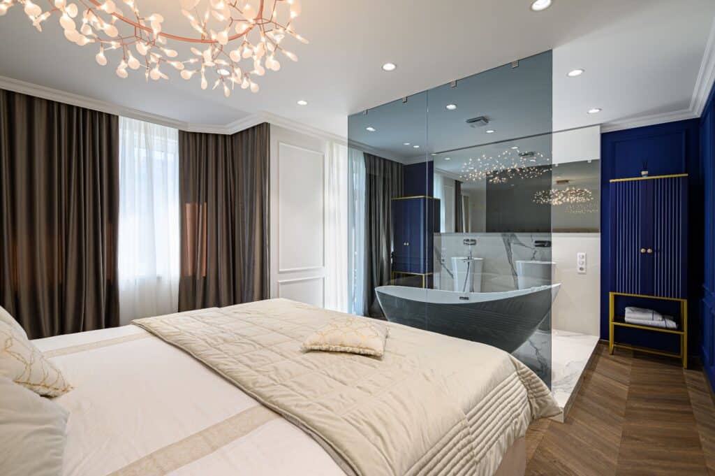 Gesund schlafen im Urlaub in einem großen bequemen Doppelbett in luxuriösem eleganten klassischen Schlafzimmer mit Bad